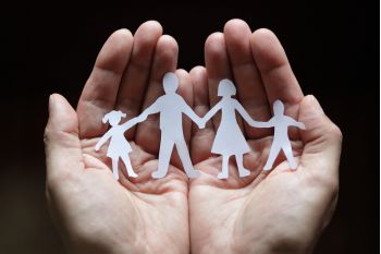 Dłonie na czarnym tle z wycinanką rodziny