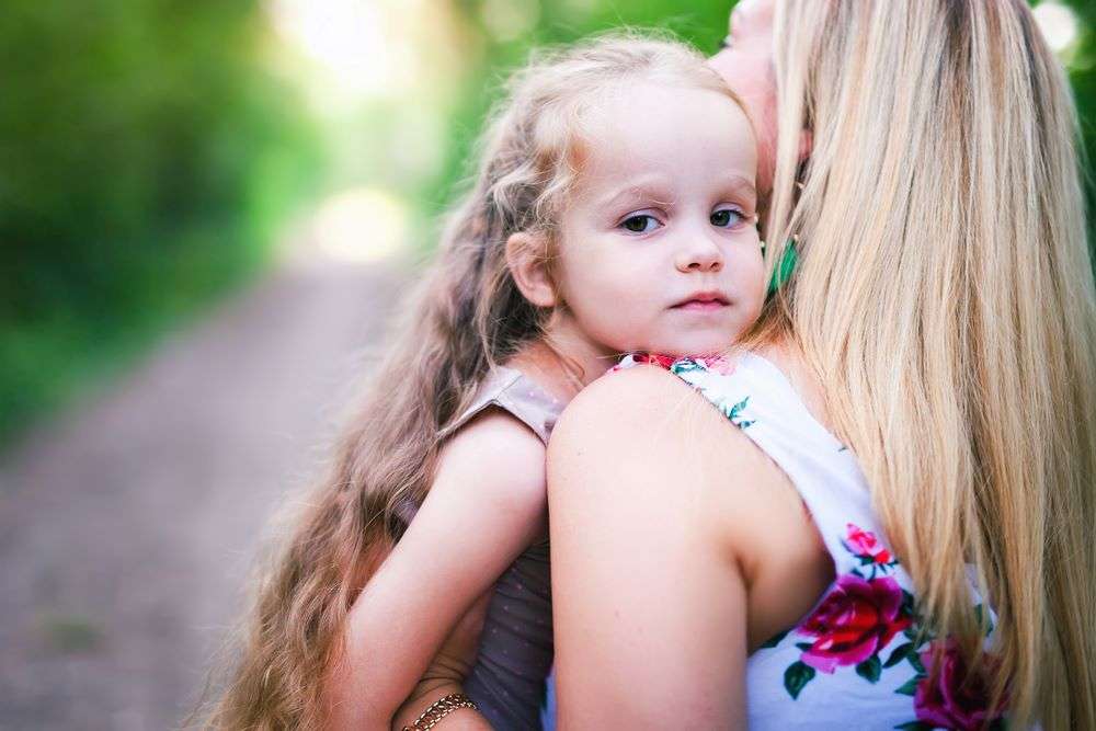 Matka niesie córkę na rękach