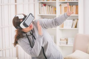 Jak działa Wirtualna rzeczywistość w leczeniu uzależnienia od alkoholu? Na zdjęciu kobieta w goglach VR