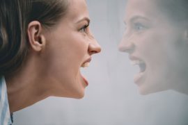 Kobieta krzyczy na swoje odbicie w lustrze