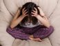Leczenie zaburzeń używania substancji wśród młodzieży. Sfrustrowana dziewczyna siedzi na łóżku z głową w rękach